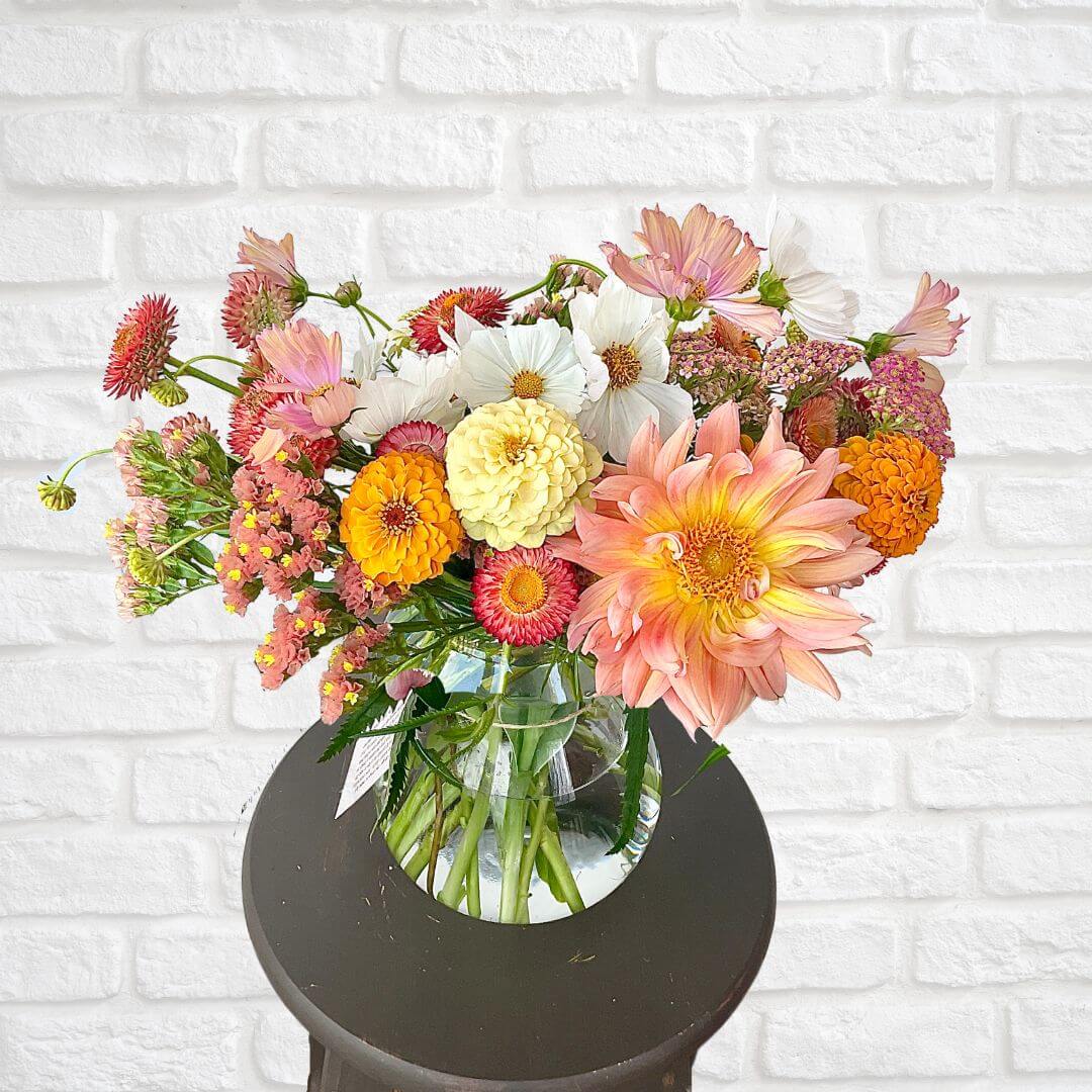 Beautiful seasonal flower arrangement of peach, ivory and pastel colored blooms. 
