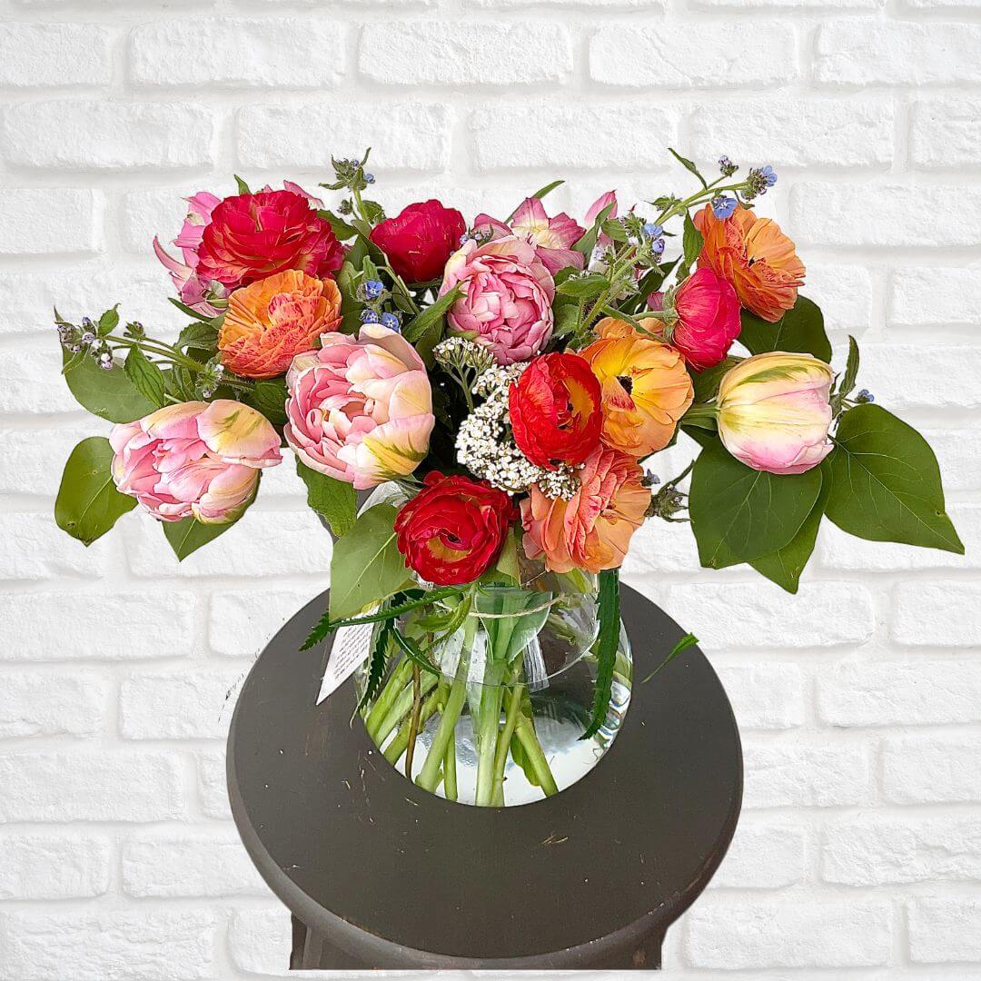 Gorgeous flower arrangement of blush, coral and golden colored blooms featuring specialty blooms that you will only find with locally grown flowers. 