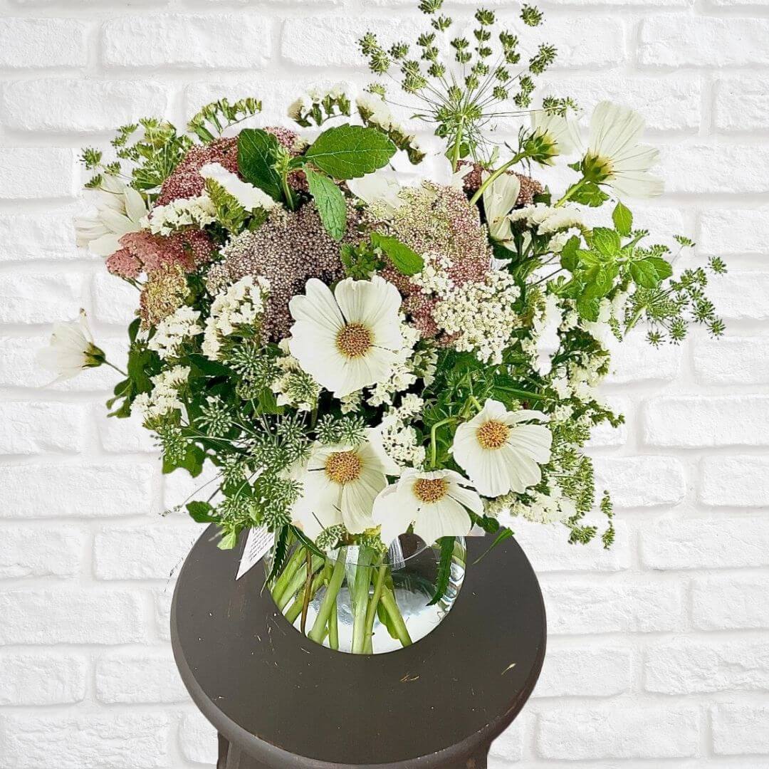 Beautiful seasonal vase arrangement of white, blush and soft pastel colored blooms. Hand arranged and presented in a glass vase with our signature twine finish.