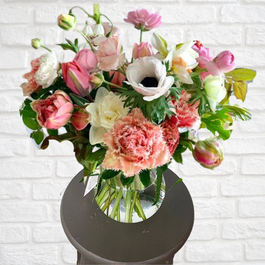 Beautiful seasonal floral arrangement of peach, salmon, and pastel colored blooms.